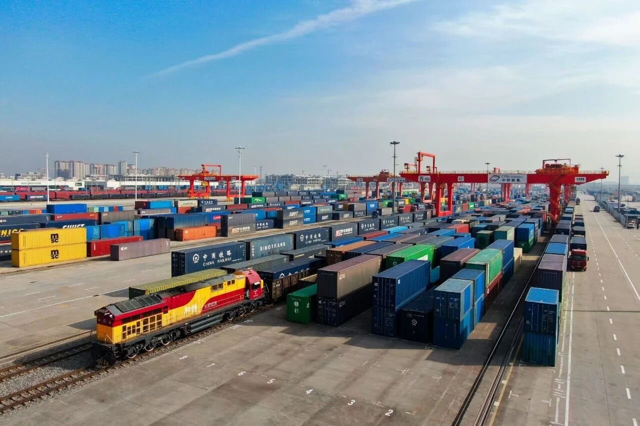 Aerial view of a dense rail yard with scheduled container block trains